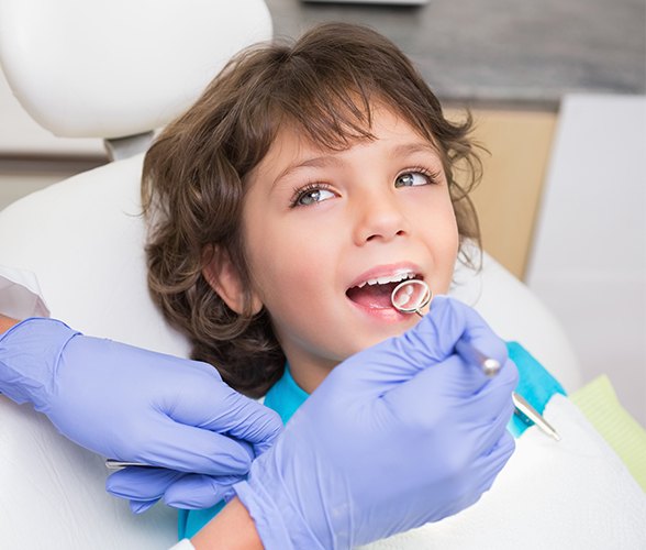 Child receiving children's dental checkup and teeth cleaning